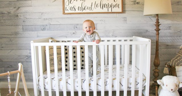 Oliver standing in crib.